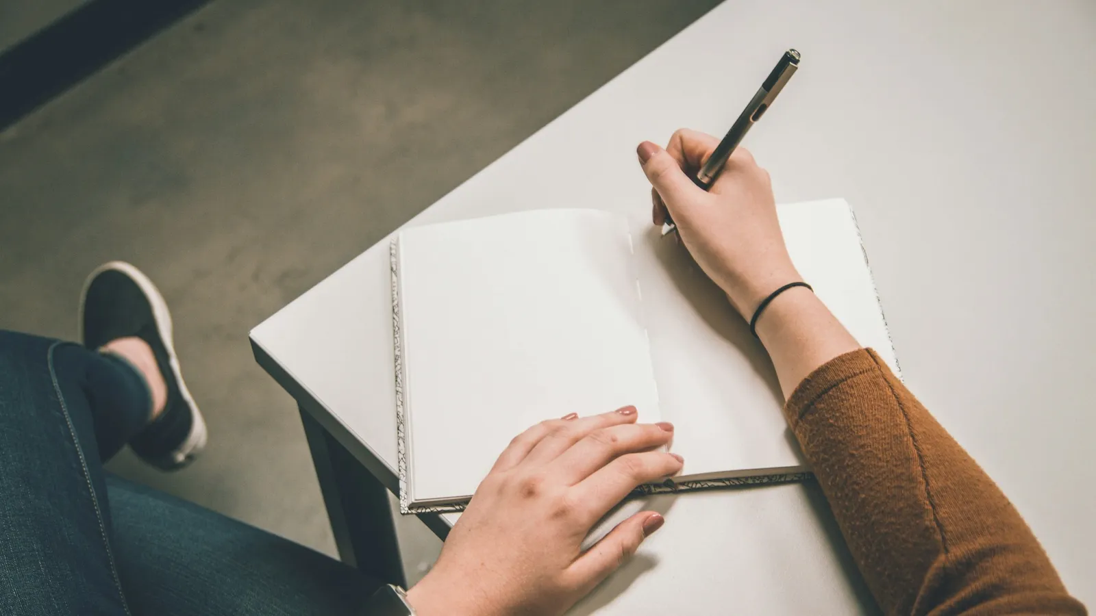 A hand writing with a pen on a sheet of paper