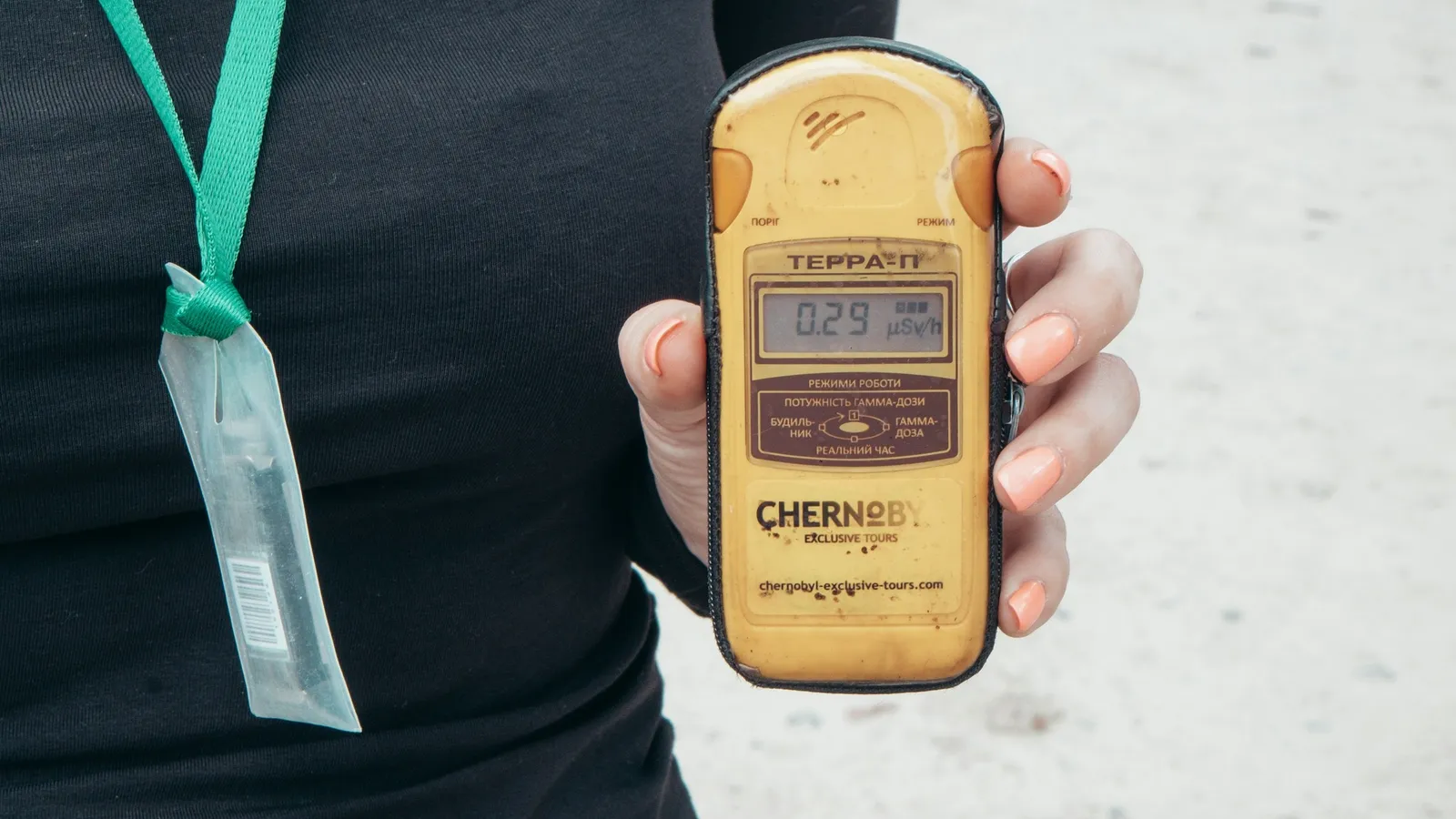 A handheld radiation counter held up outdoors