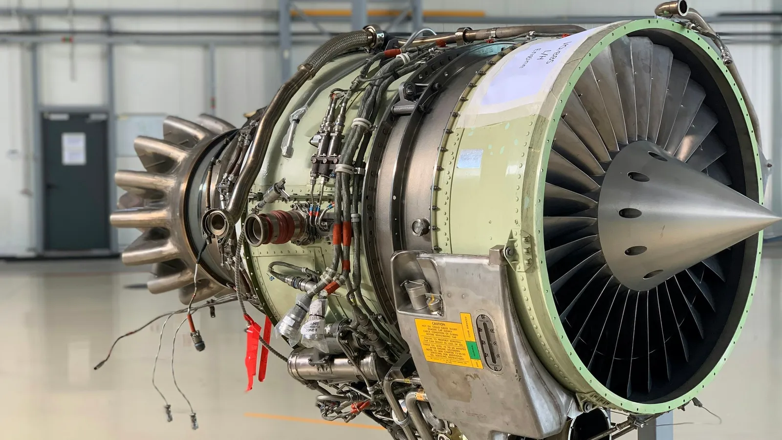 A jet engine with its casing removed in a hangar