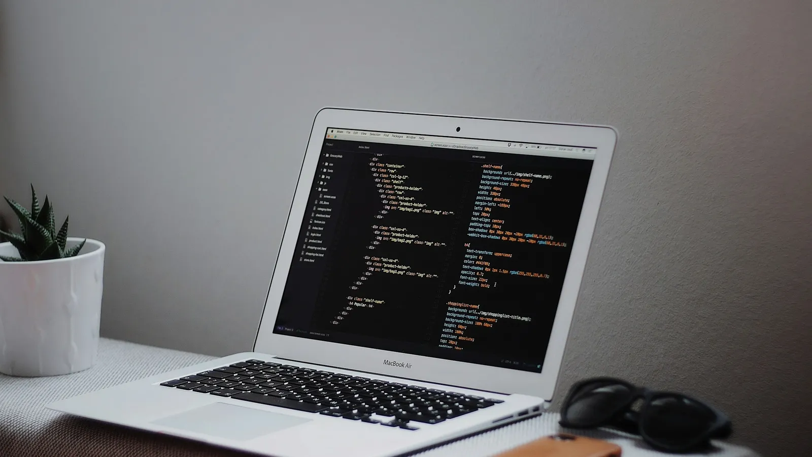 A laptop on a desk displaying code