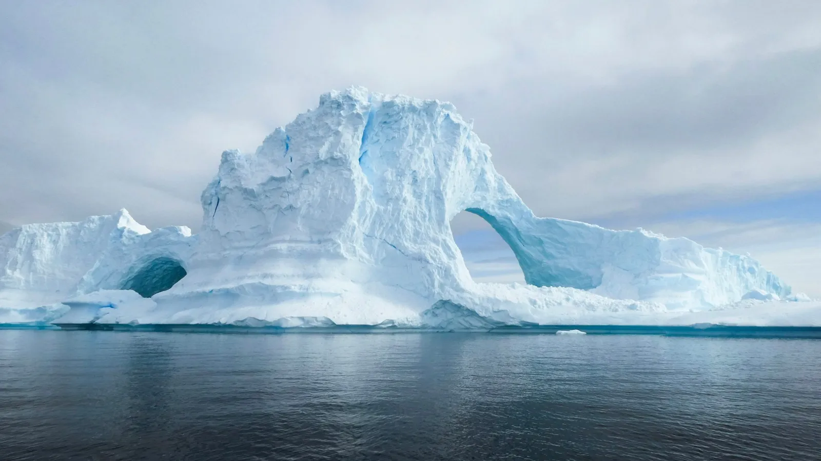 A large iceberg floating in calm water