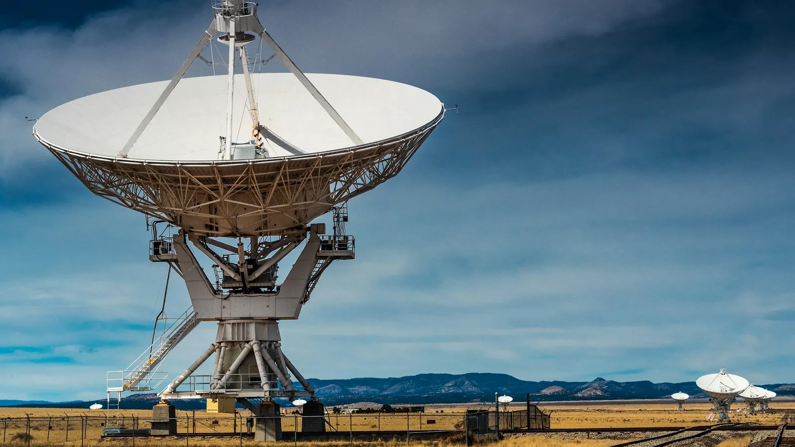 A large radio telescope dish under a cloudy sky