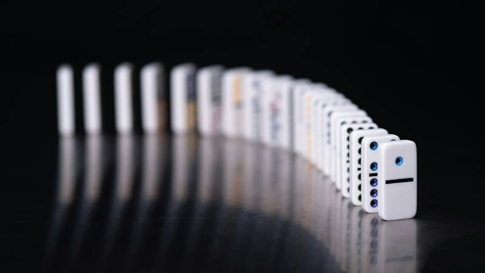 A line of dominoes toppling over