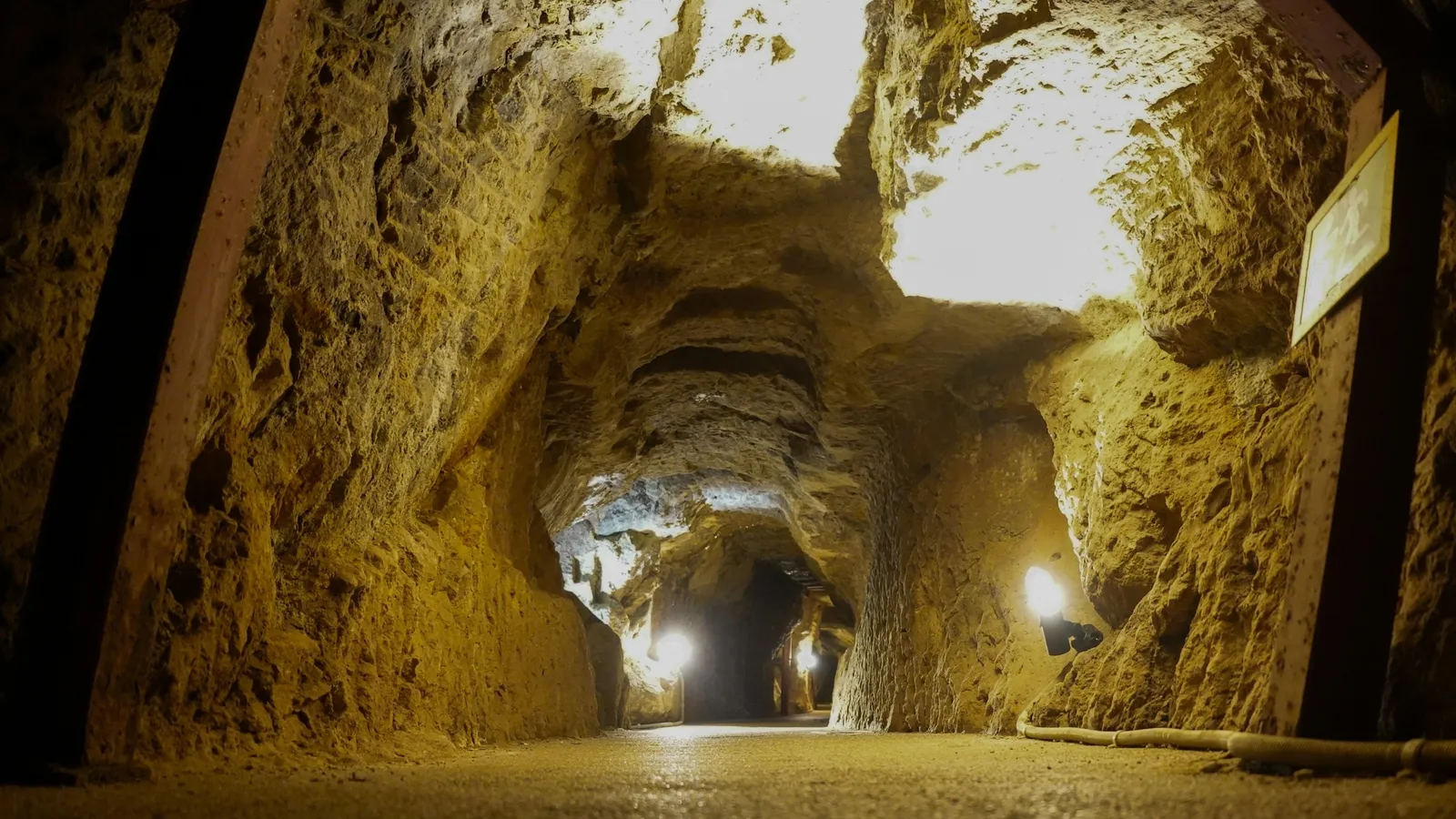 A lit tunnel running deep into an underground mine
