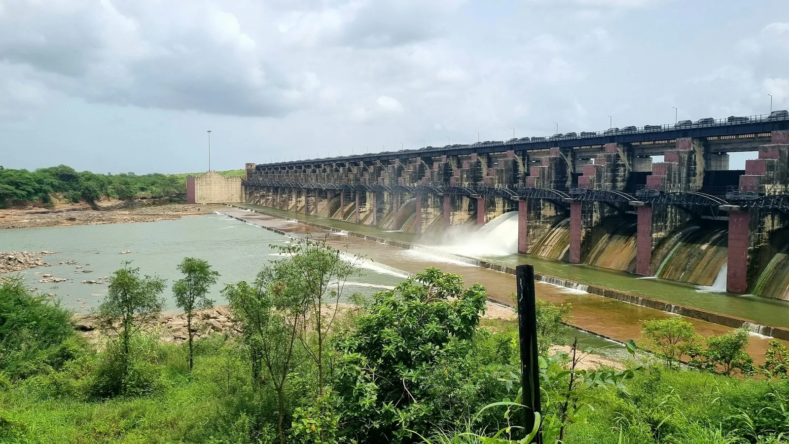 A long dam releasing water into a river below
