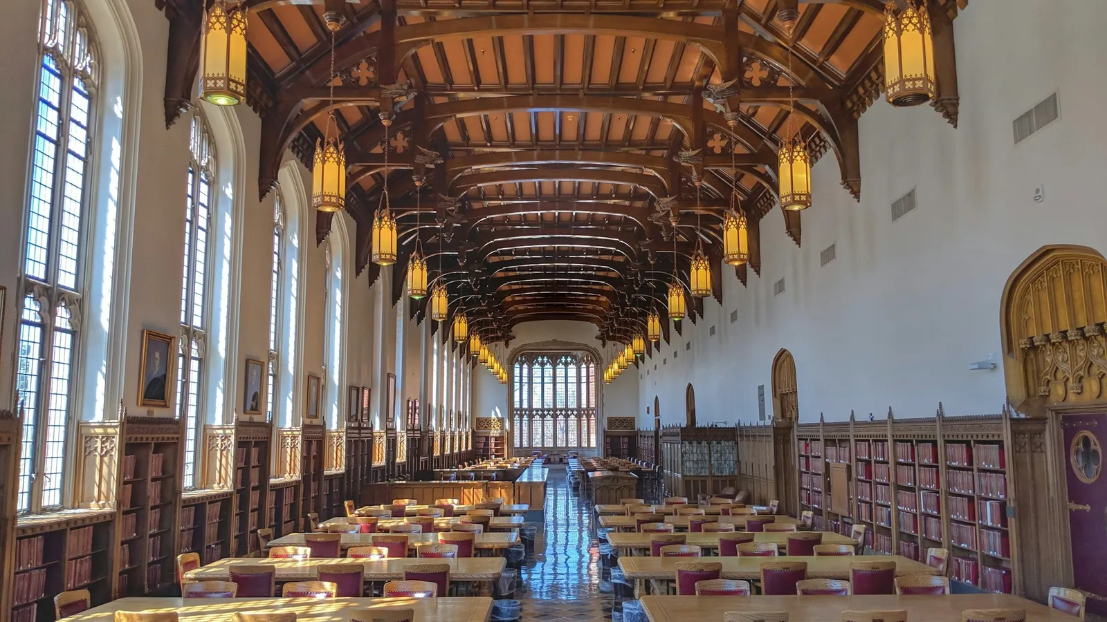 A long library reading room with rows of desks