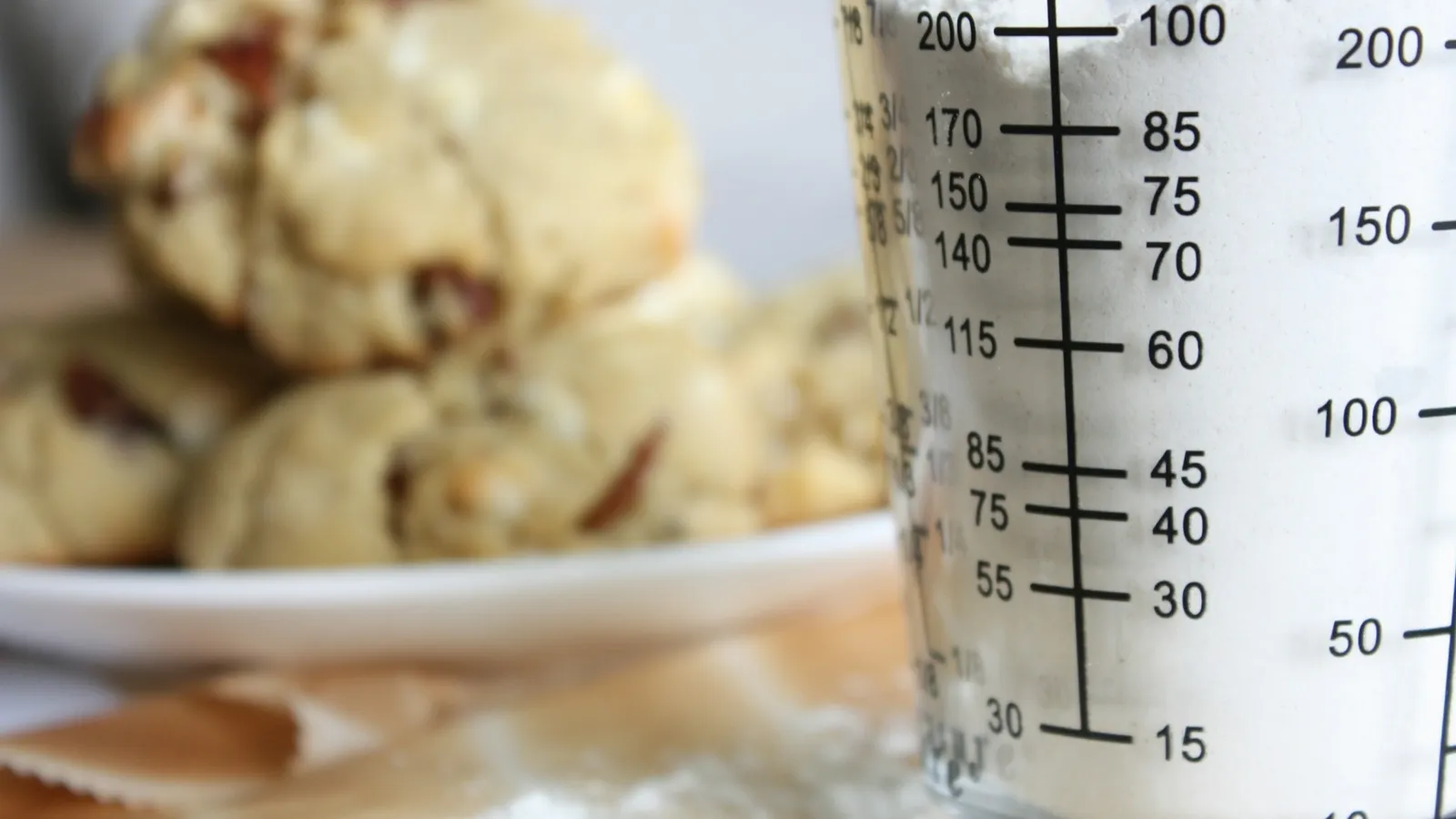 A measuring jug marked in millilitres beside cookies