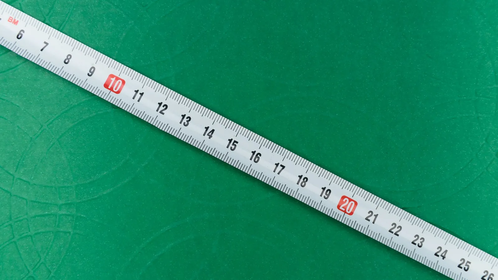 A measuring tape marked in centimetres on green