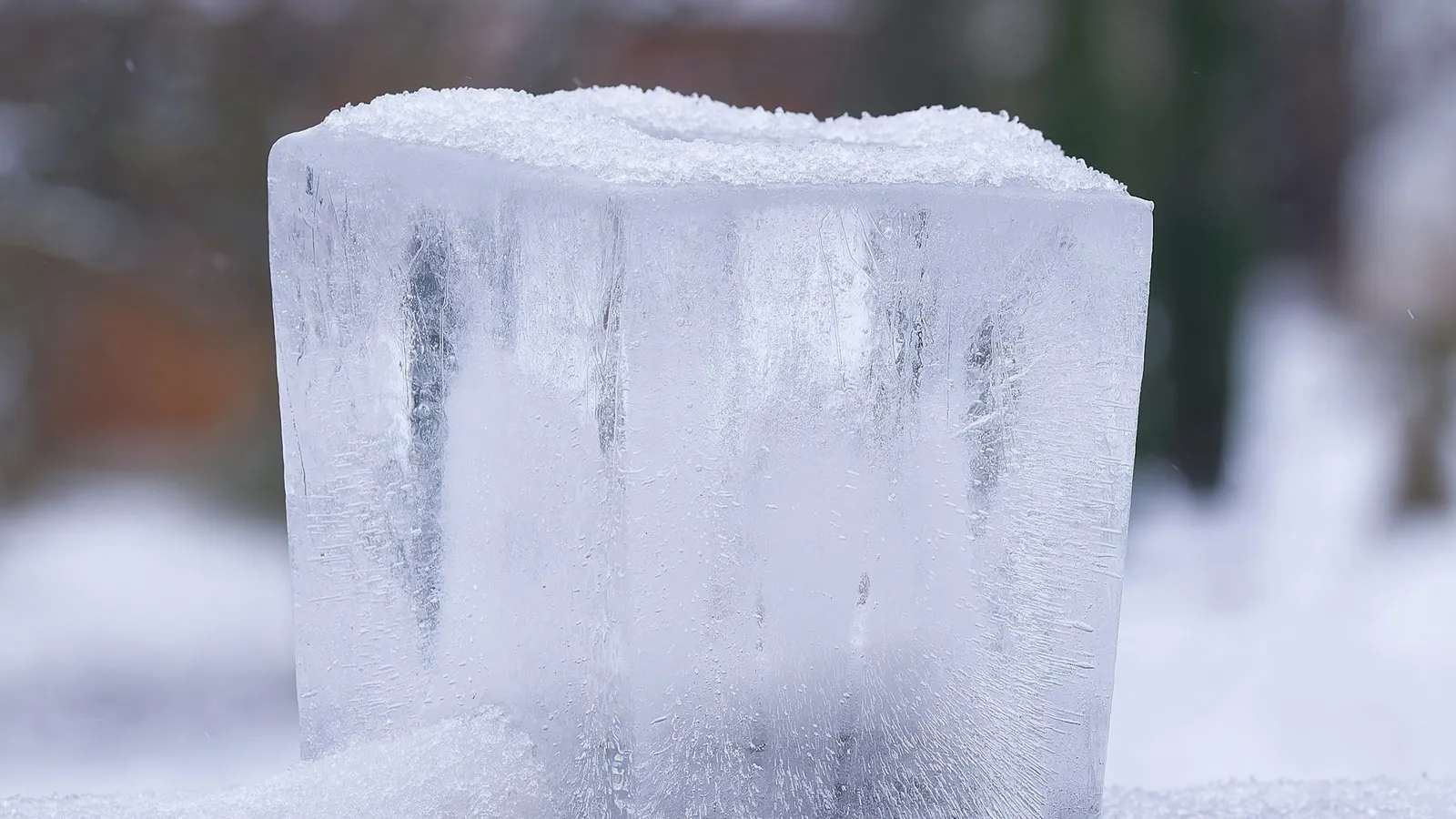 A melting block of ice standing in the snow