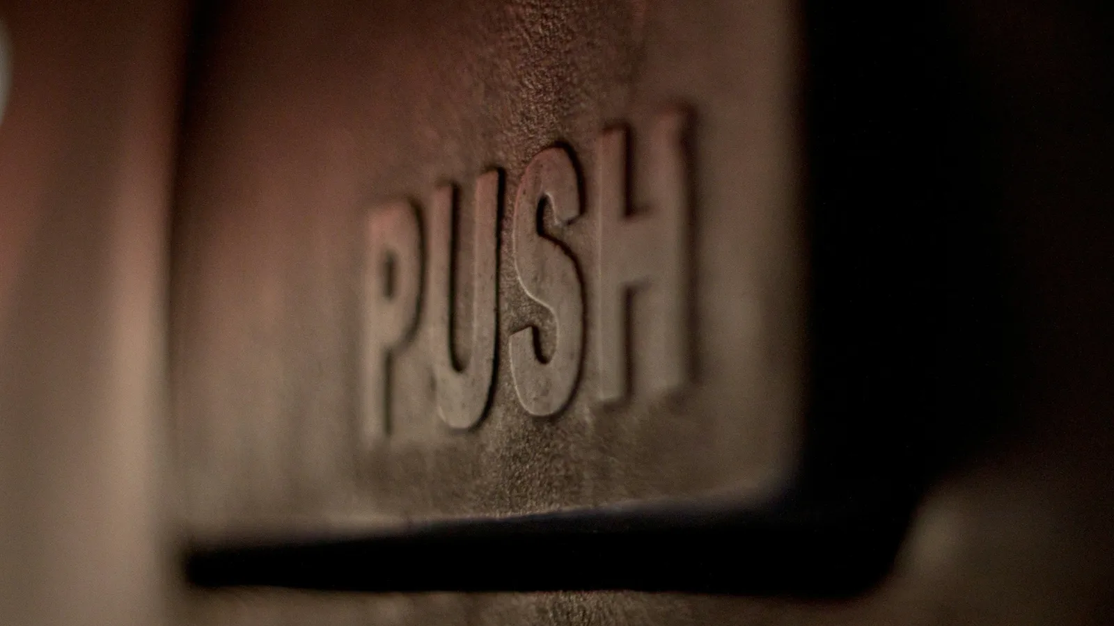 A metal push plate on a door, close up