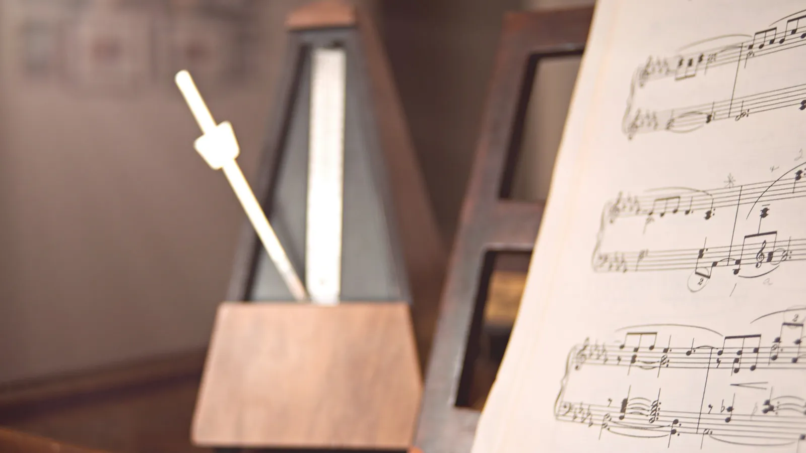 A metronome swinging beside sheet music