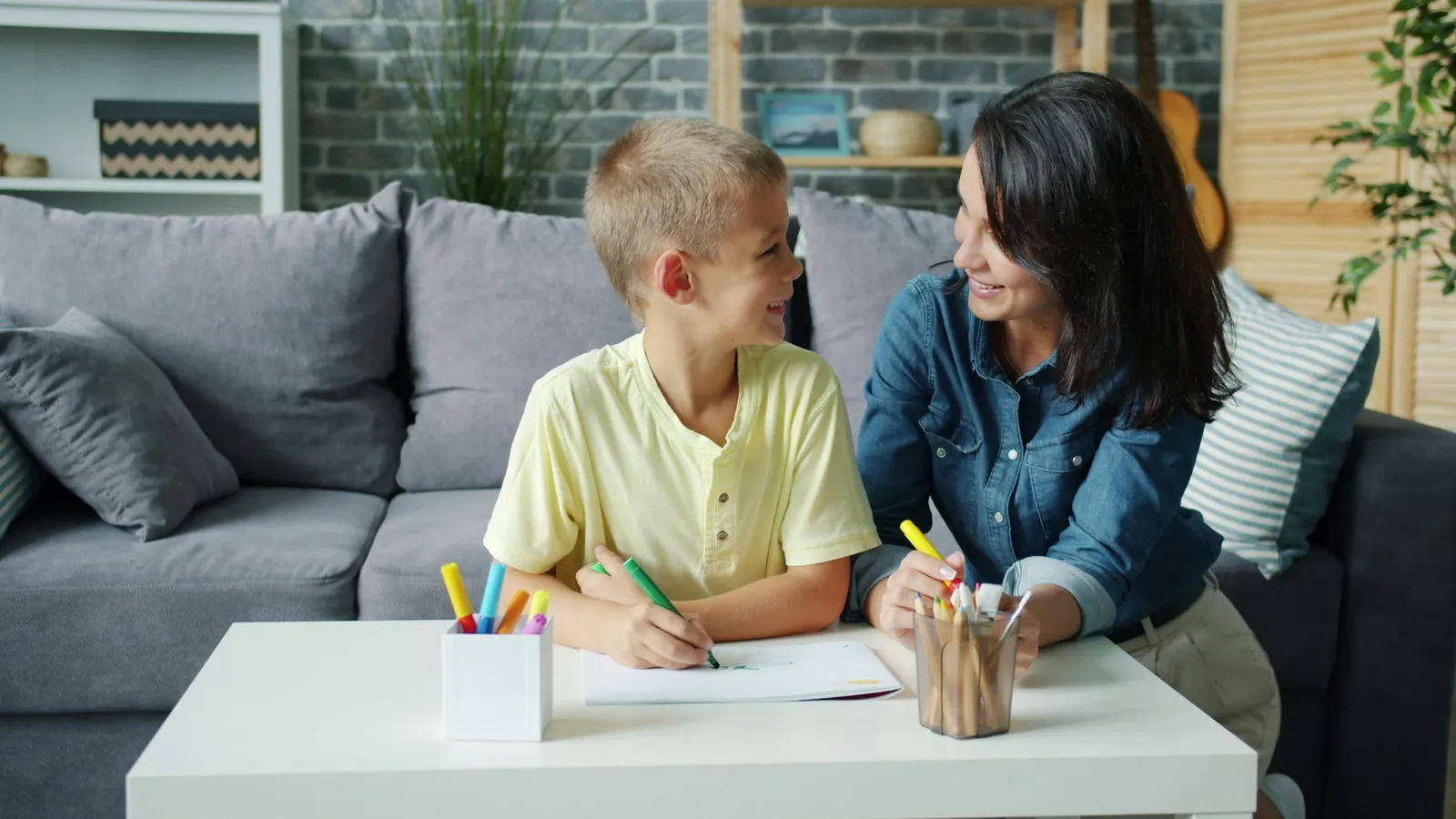 A mother and son drawing together at a low table