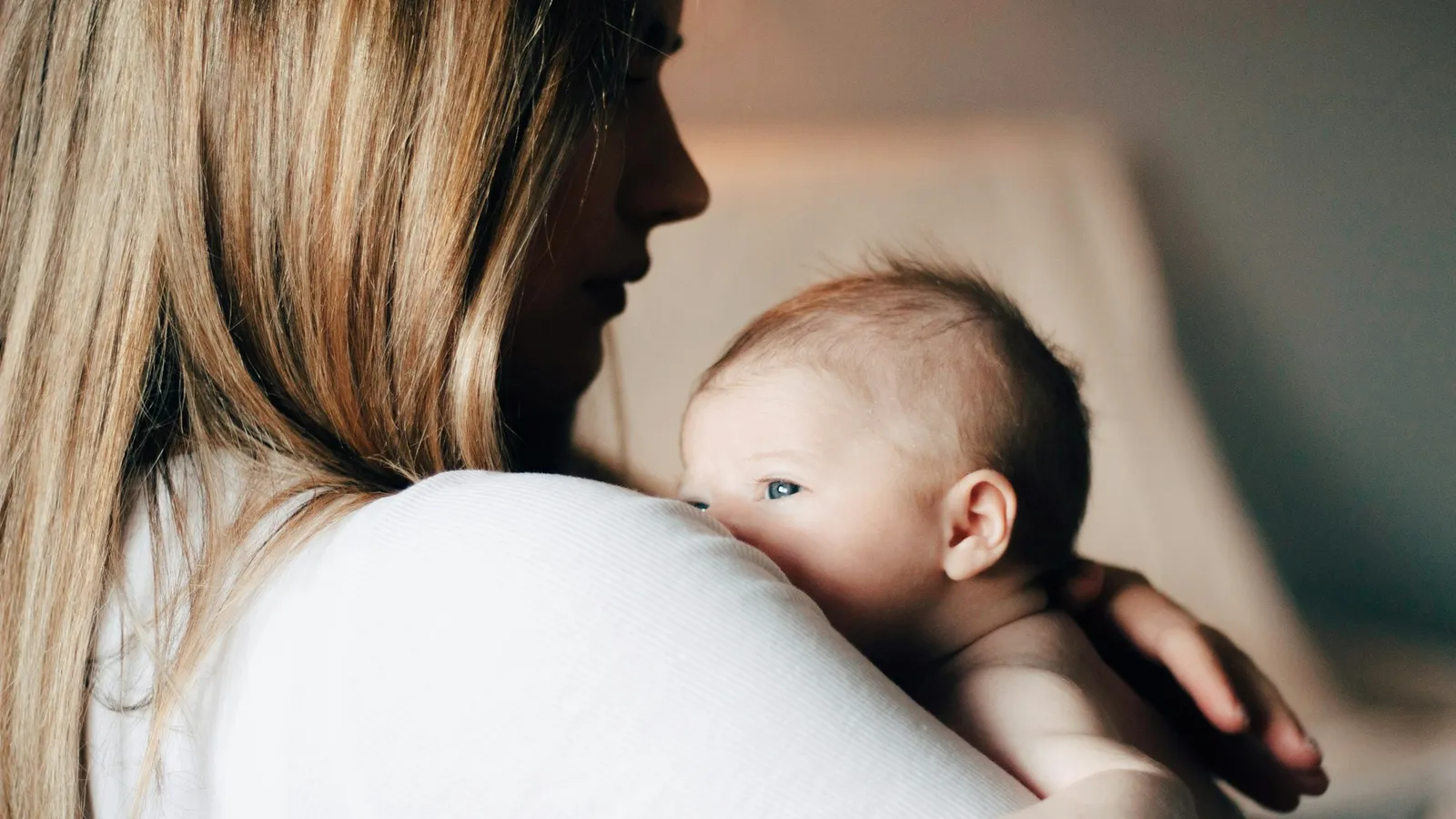 A mother holding her newborn baby close