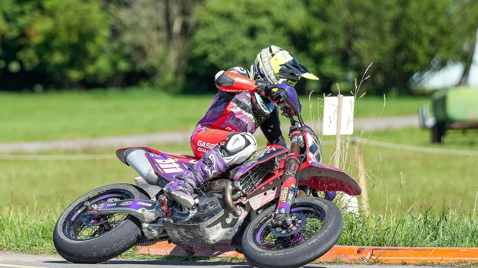 A motorcyclist leaning into a curve on a track