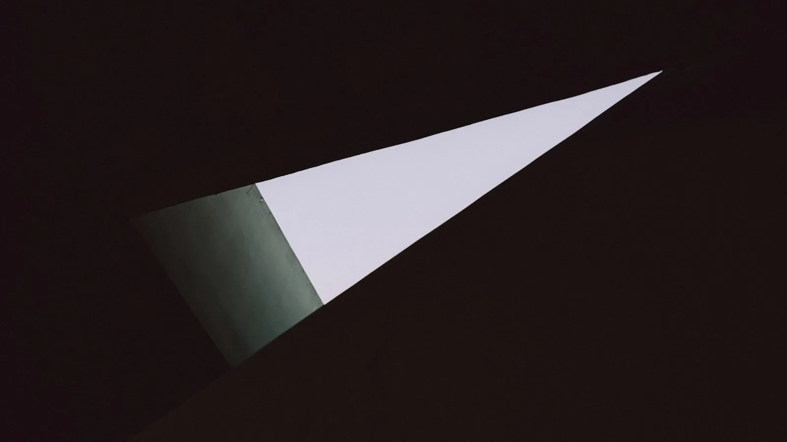 A narrow wedge of light shining into a dark room