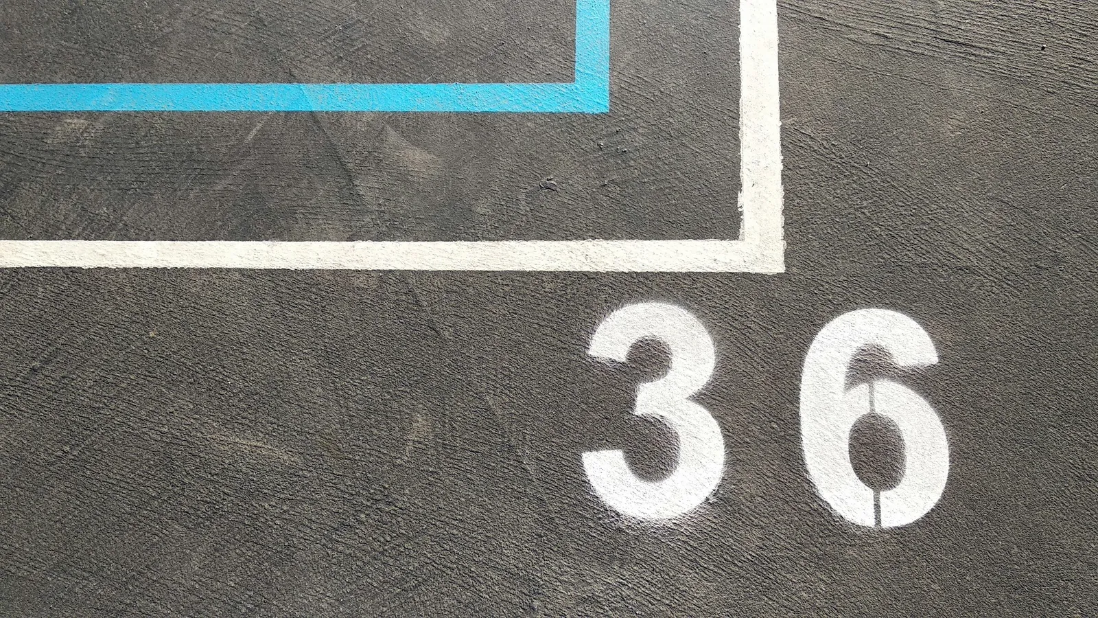 A number painted in white on a dark playground surface