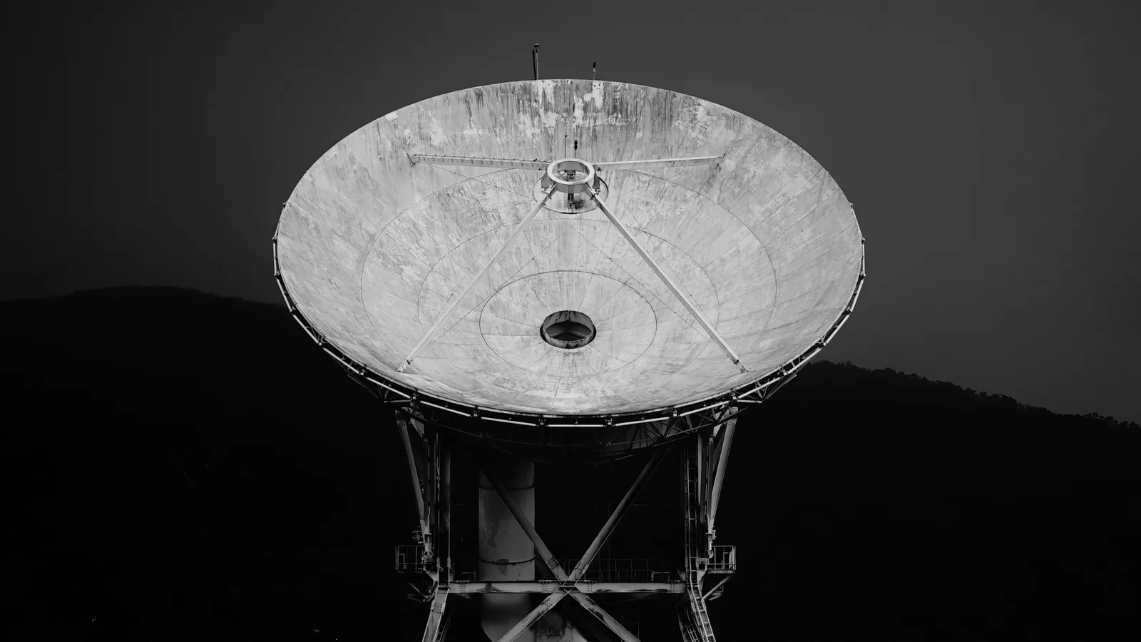 A parabolic satellite dish in black and white