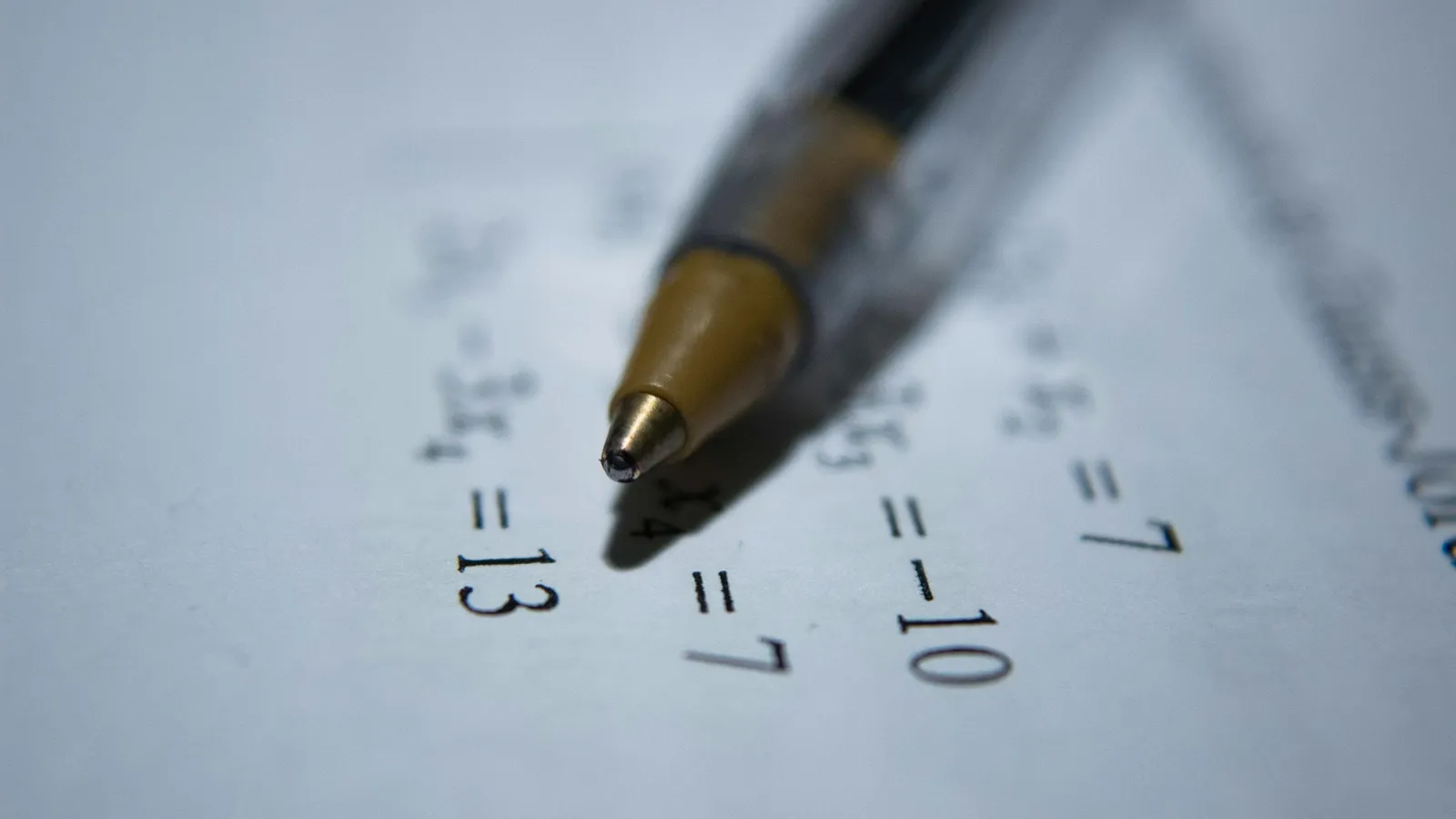 A pen resting on handwritten maths on paper