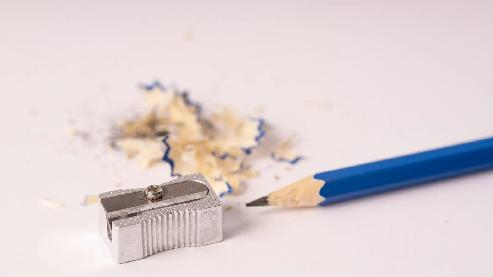 A pencil beside eraser shavings on white paper