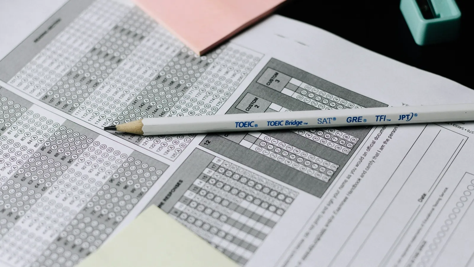A pencil lying across printed multiple-choice answer sheets