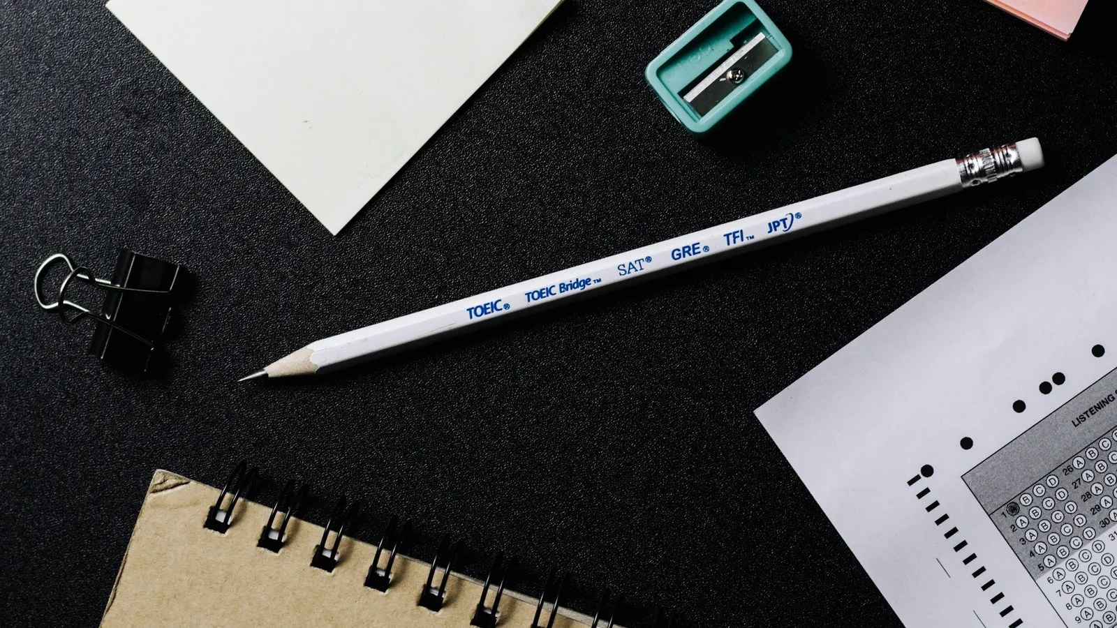 A pencil lying beside an answer sheet on a dark desk