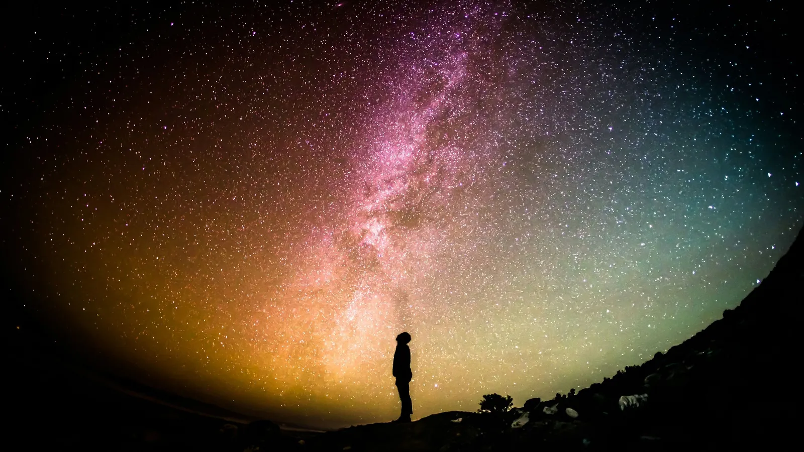 A person standing under the Milky Way at night