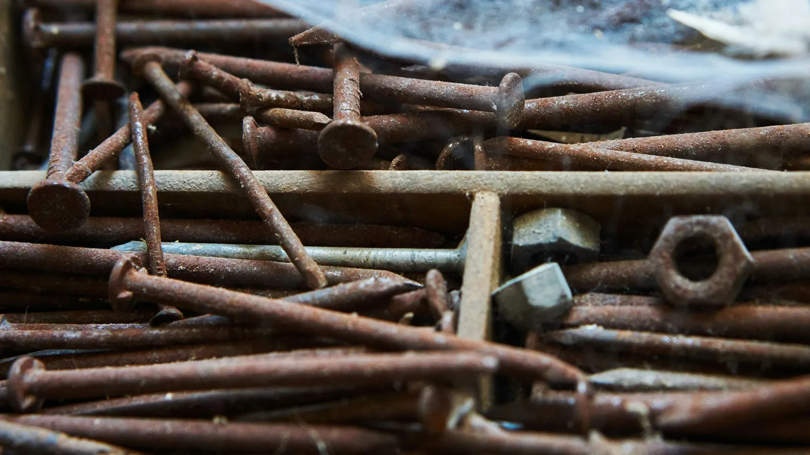 A pile of rusty nails, bolts and metal scraps
