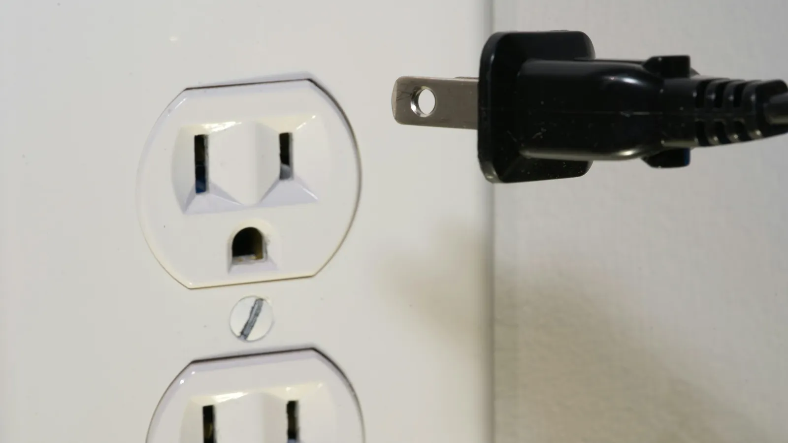 A plug being pulled from a wall socket