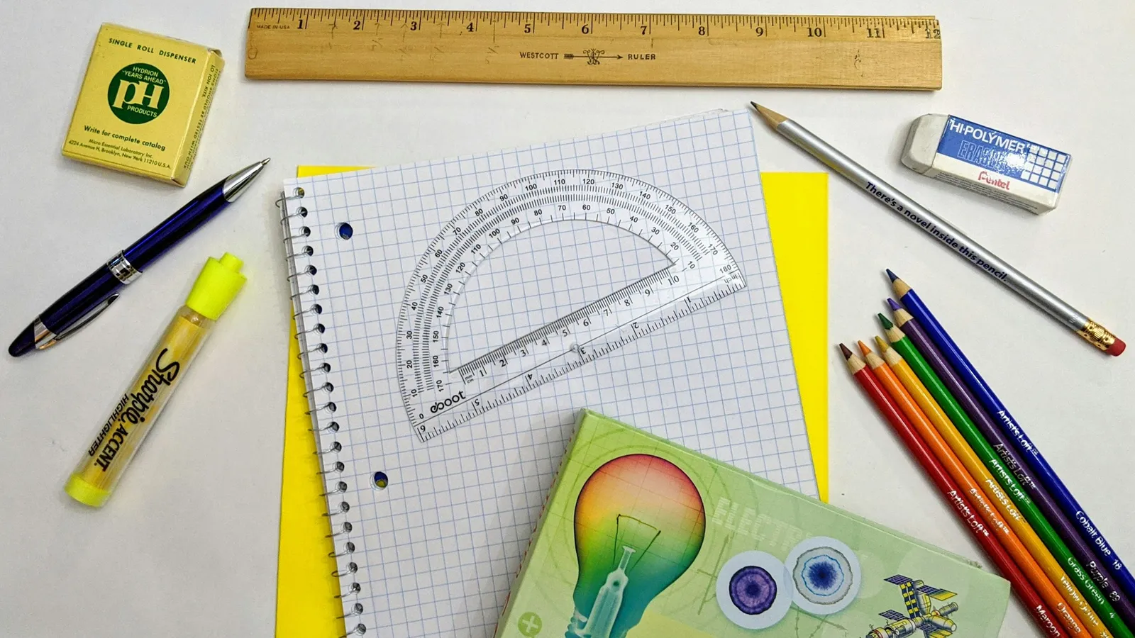 A protractor, ruler and pens on a desk