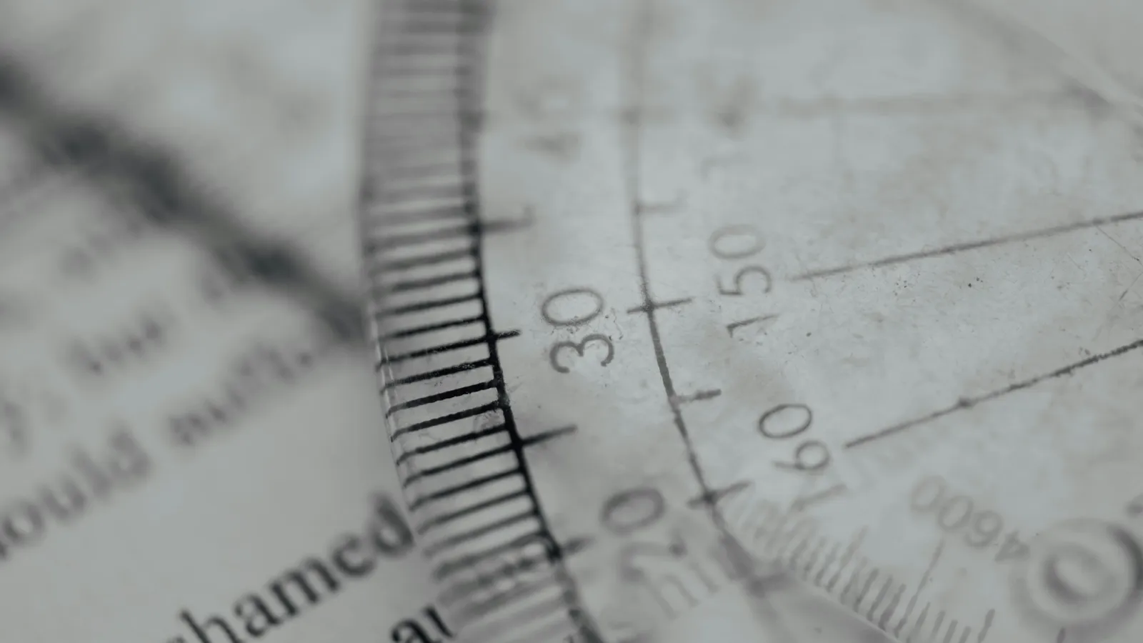 A protractor scale seen close up over printed text