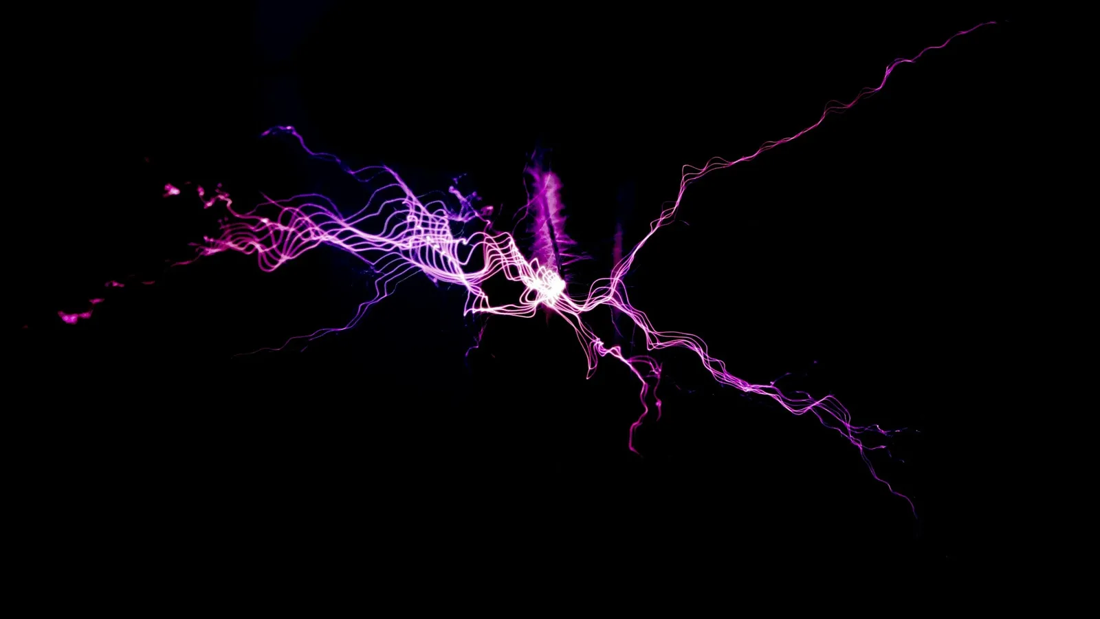 A purple electric spark branching in the dark