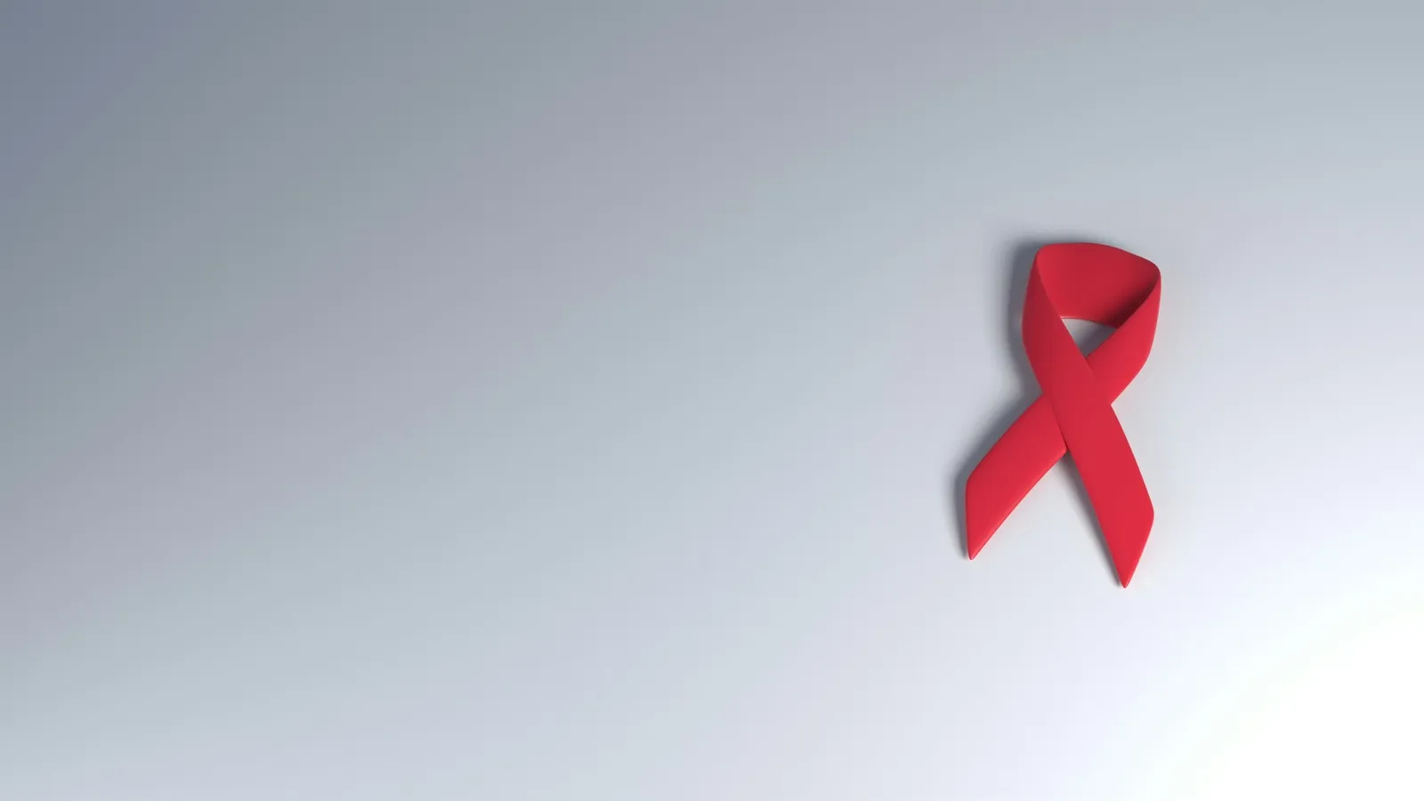 A red awareness ribbon on a pale background