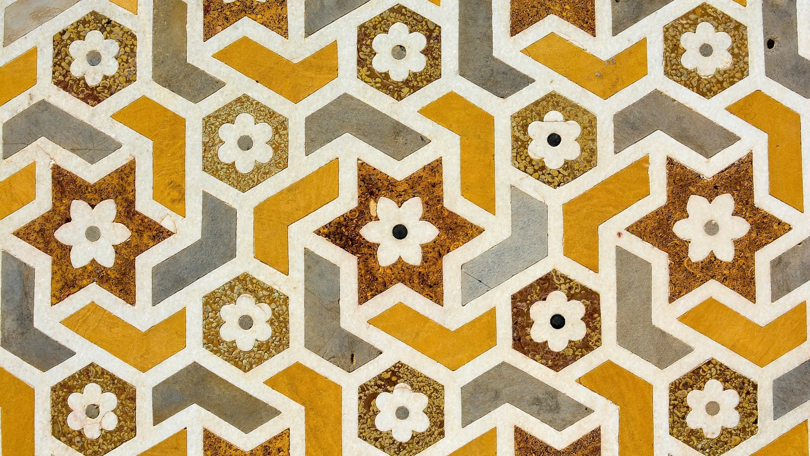 A repeating geometric star pattern in yellow and grey tiles