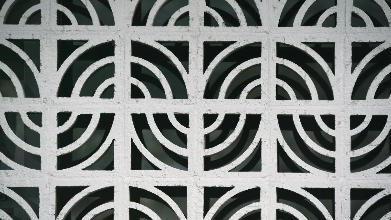 A repeating pattern of concentric circular arcs on a wall