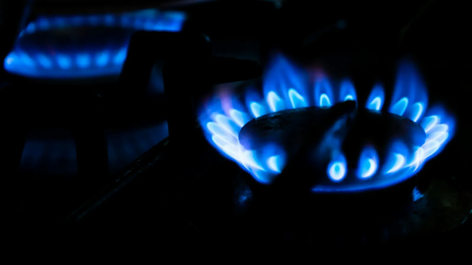 A ring of blue gas flames in the dark