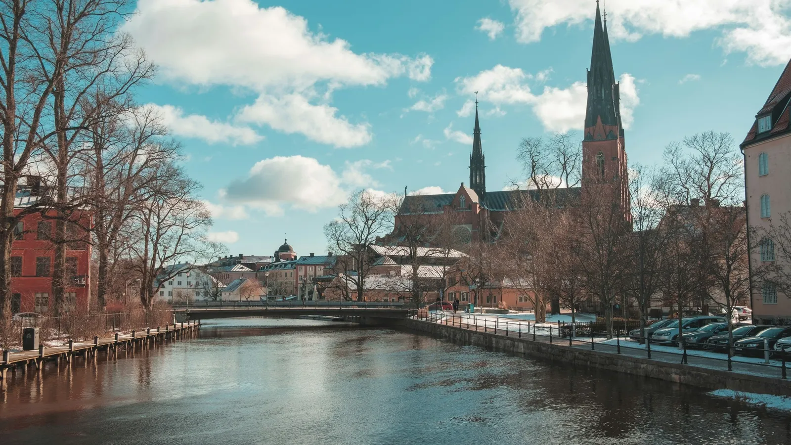 A river through a Swedish city with cathedral spires behind