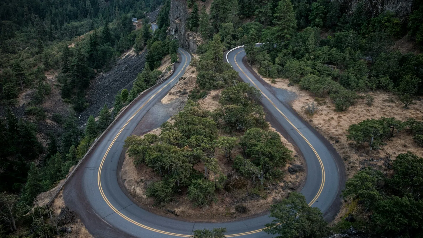A road curving back on itself through a forest