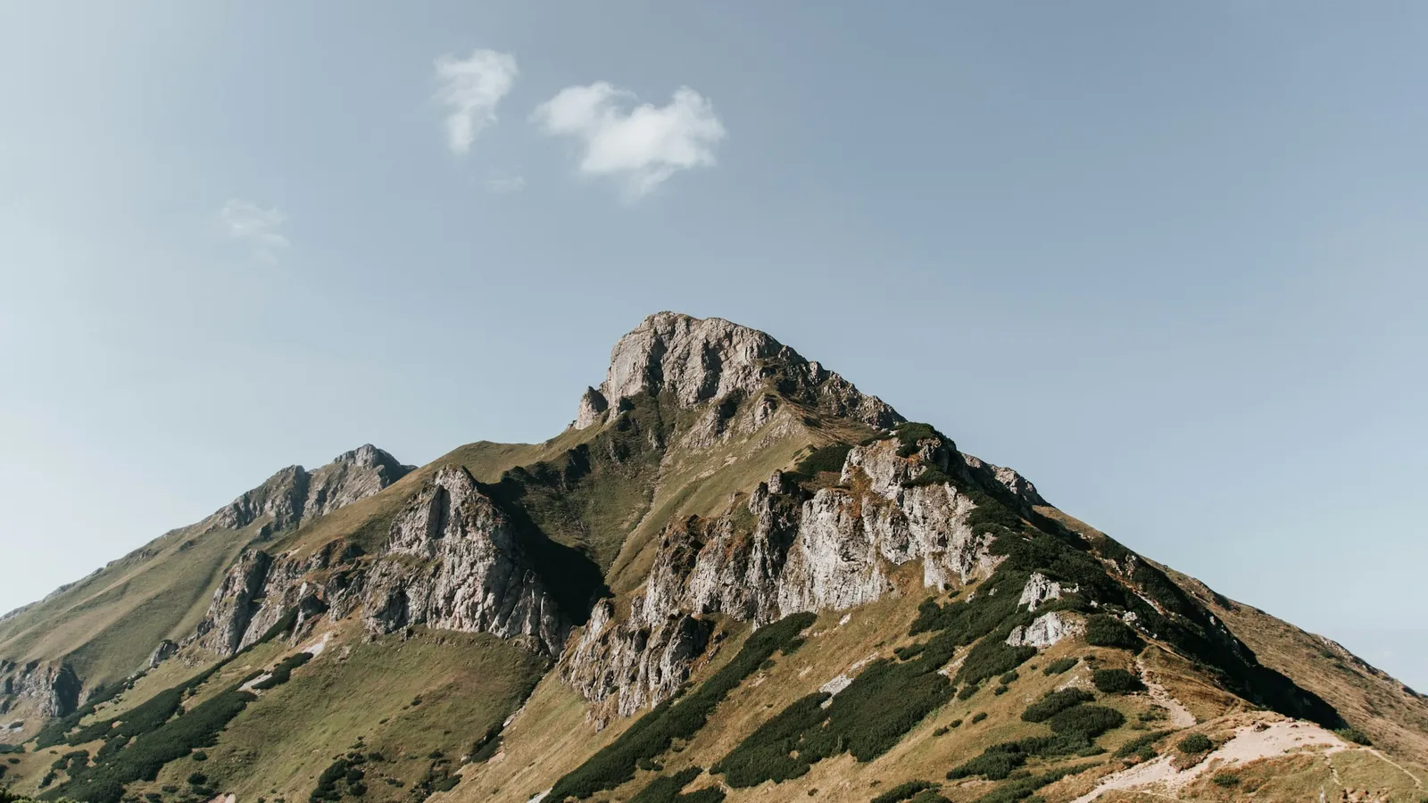 A rocky mountain summit under a blue sky