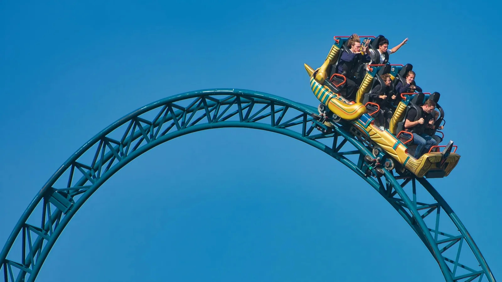 A roller coaster train riding over a curved blue track
