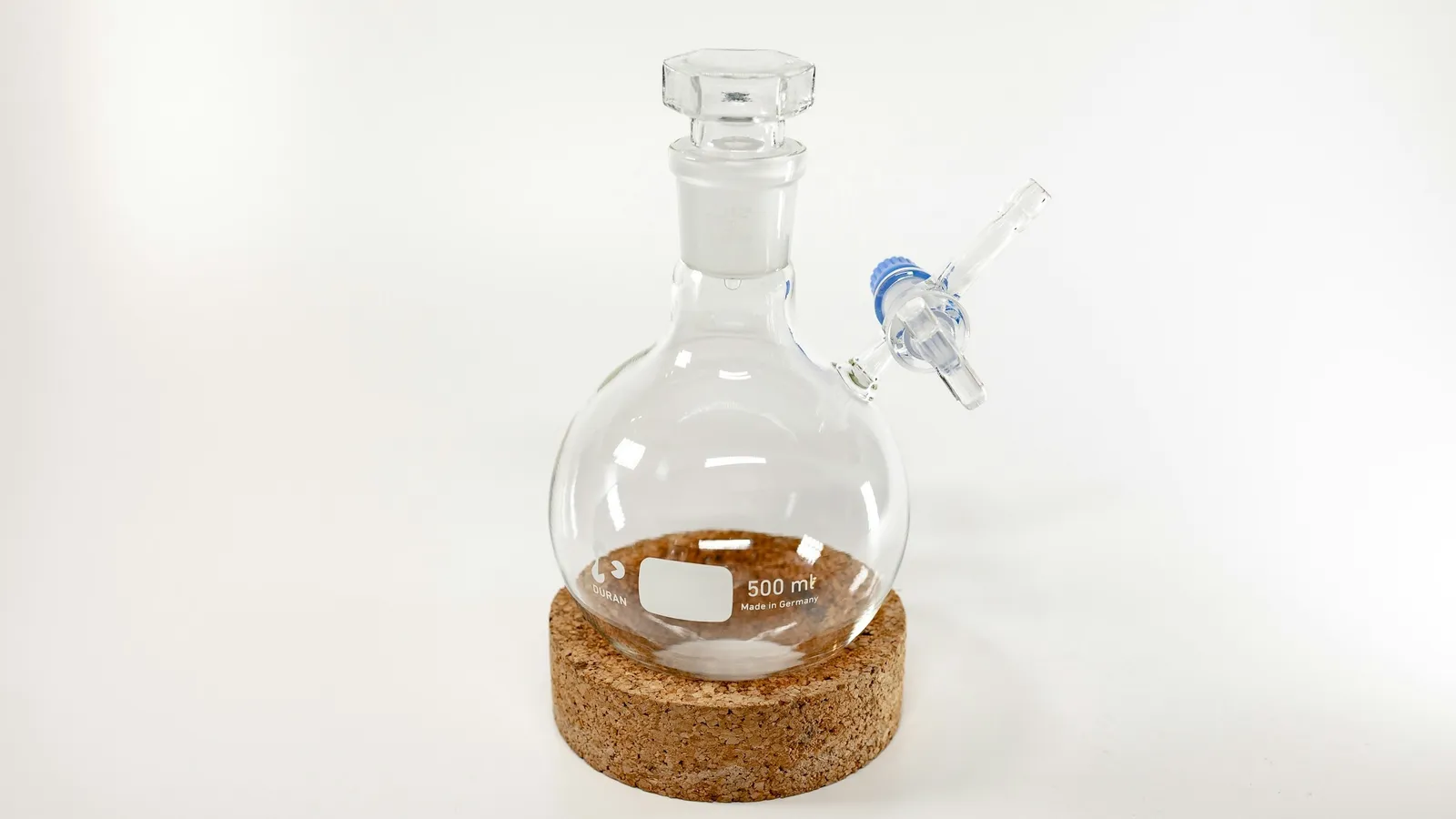A round-bottom flask with brown liquid on a cork stand