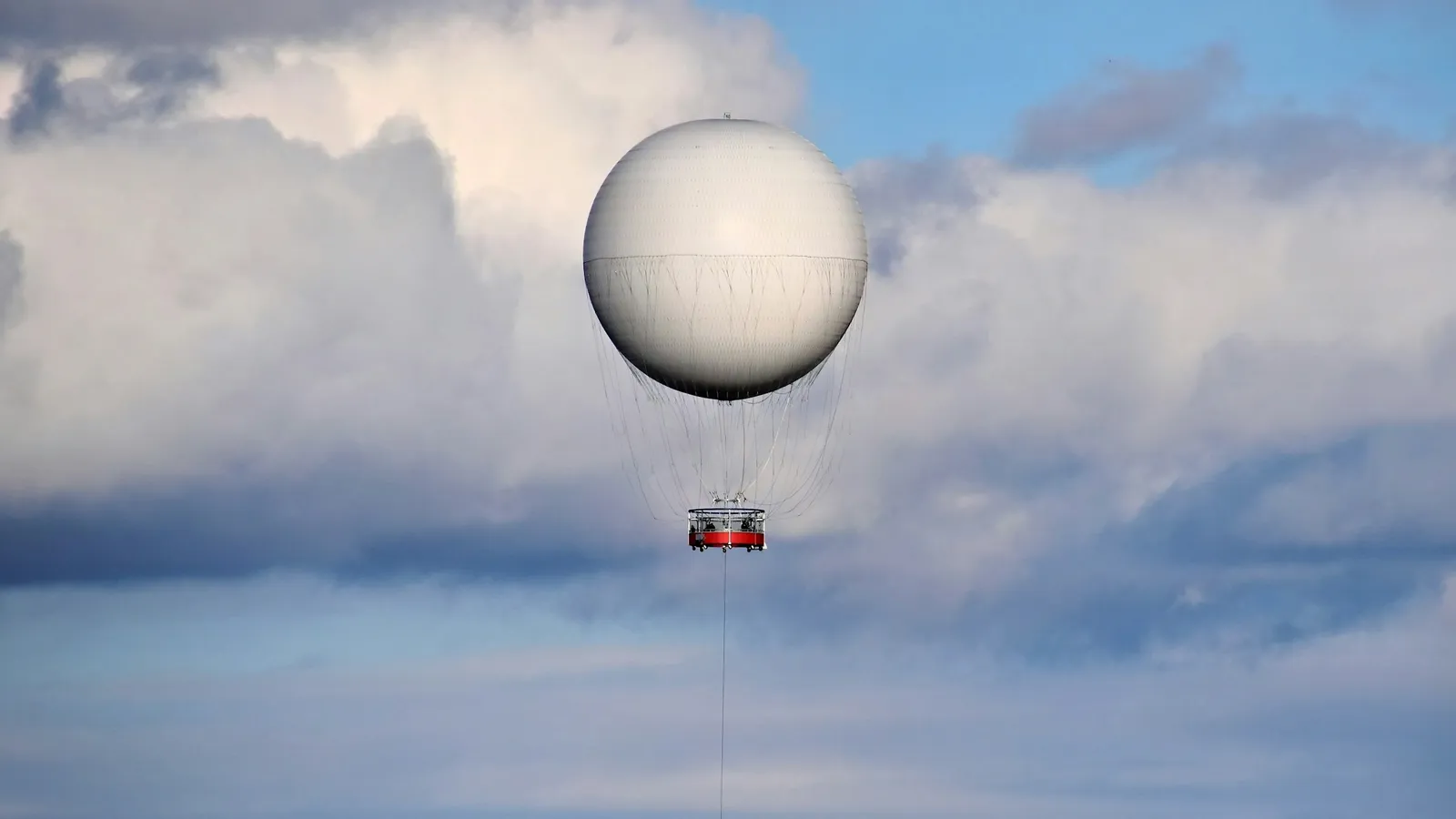 A round gas balloon floating above the clouds