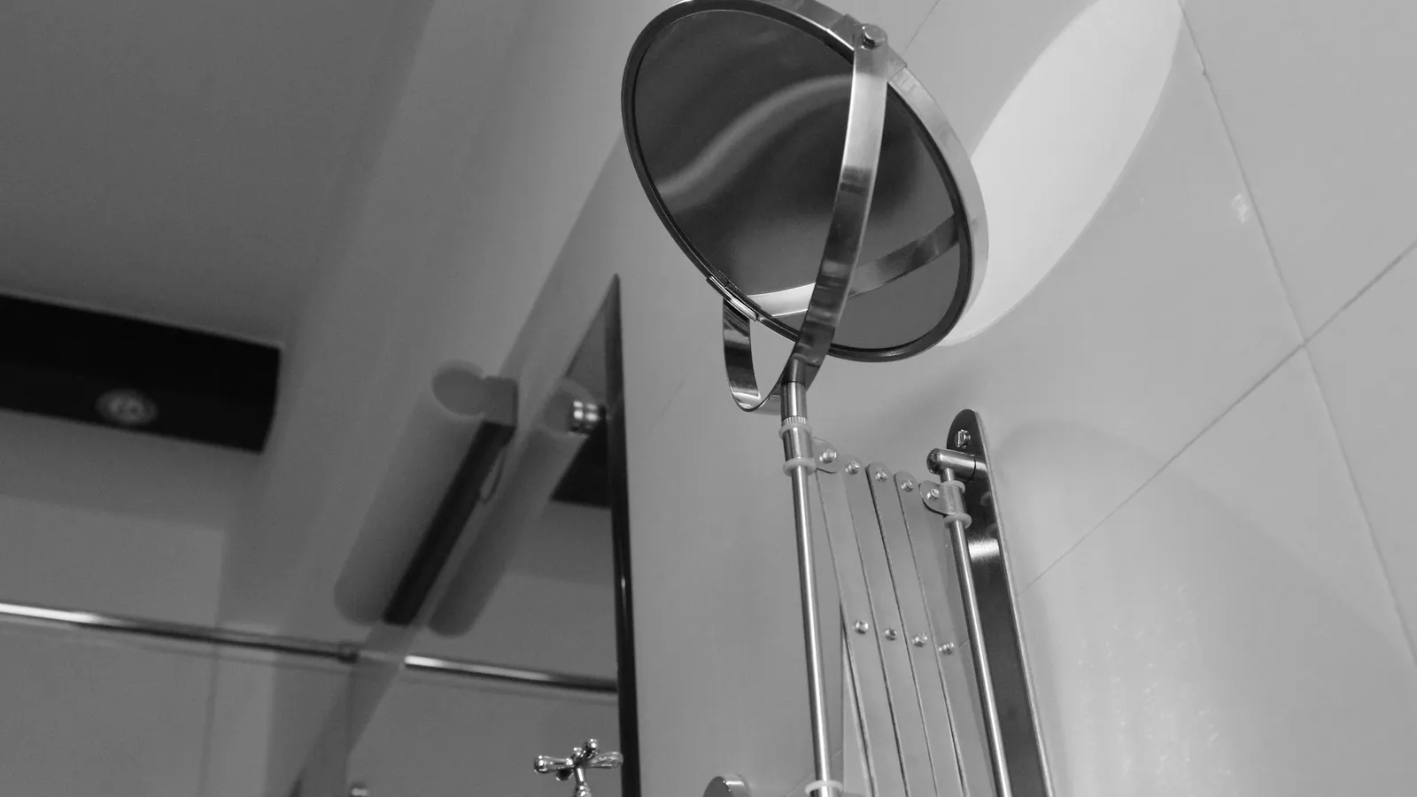 A round magnifying shaving mirror on a wall