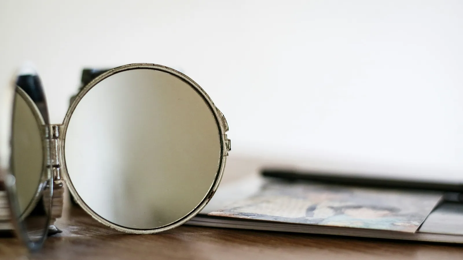 A round mirror standing beside a lens