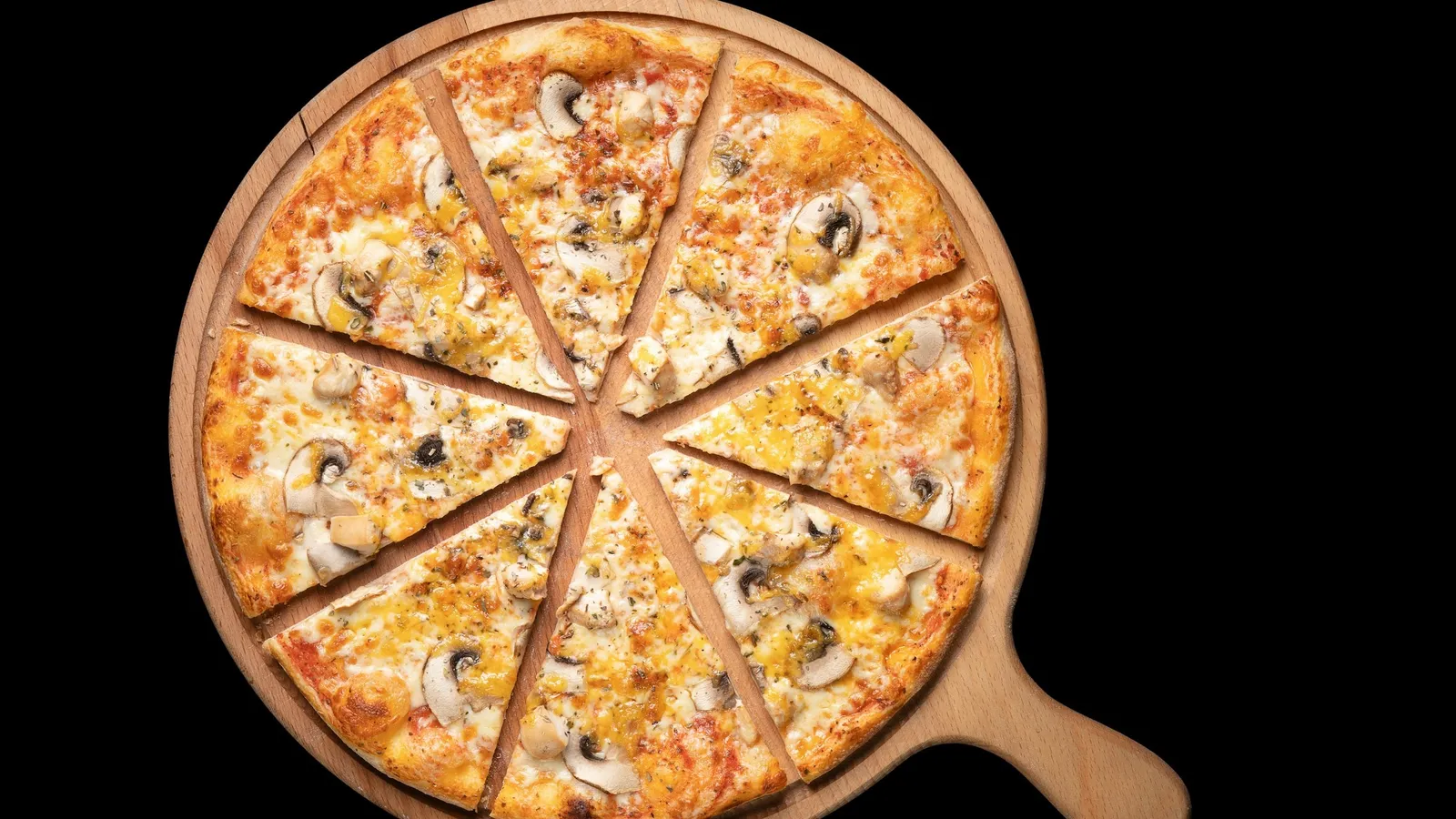 A round pizza cut into equal slices on a wooden board