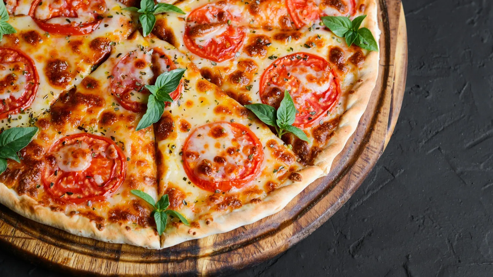 A round pizza cut into sectors on a dark board