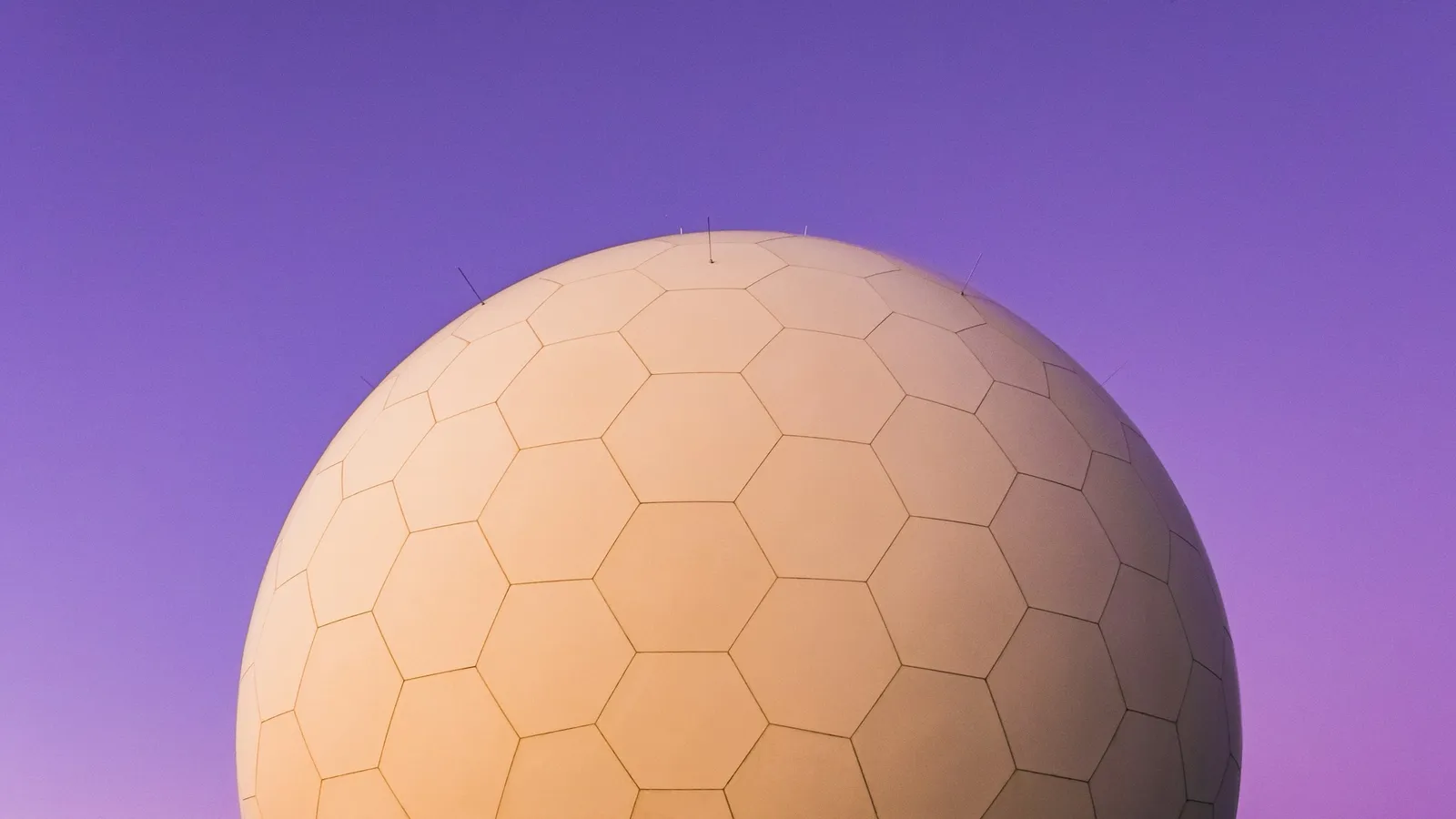 A round white radar dome against a purple sky