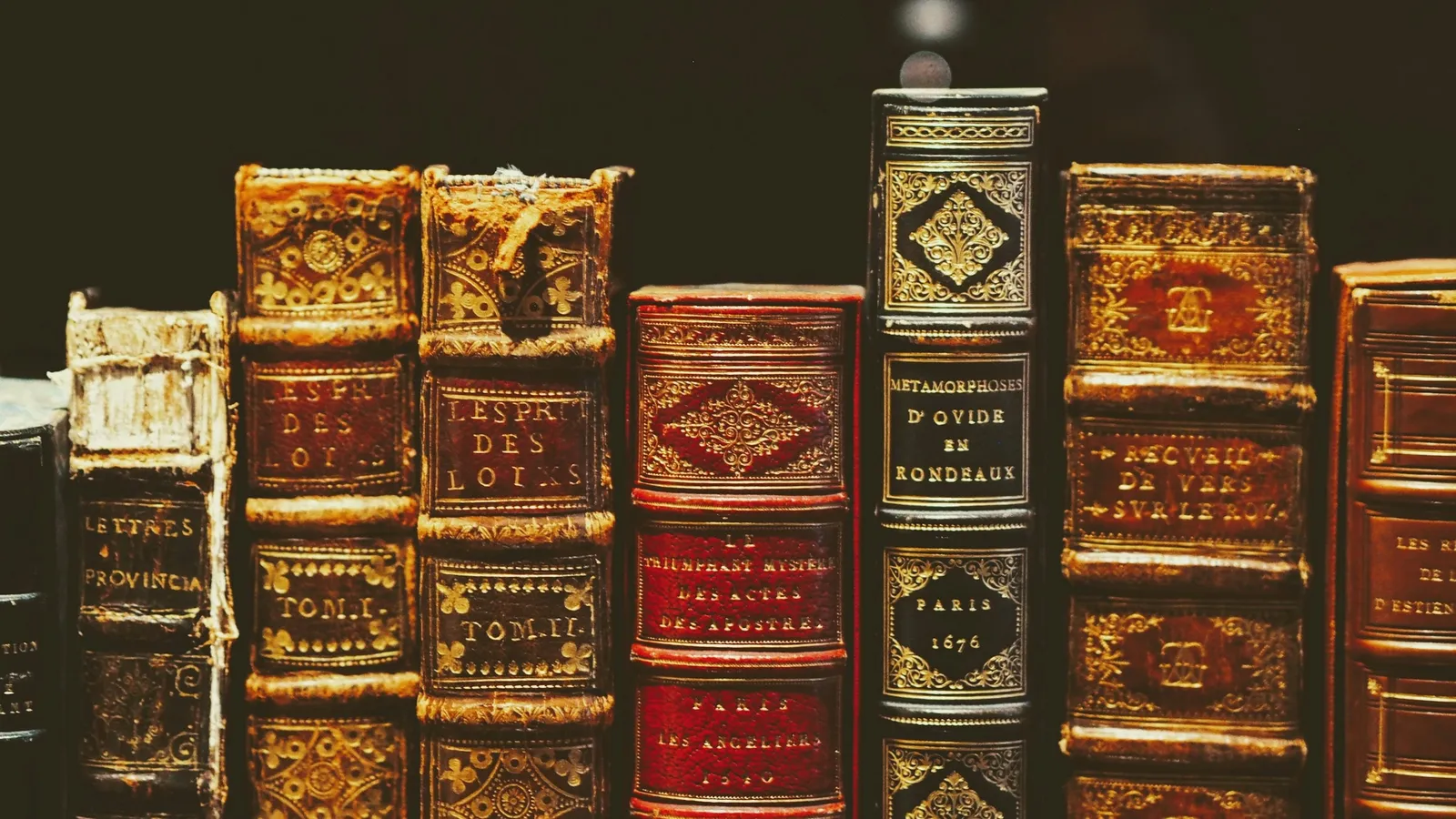 A row of old leather-bound books on a shelf