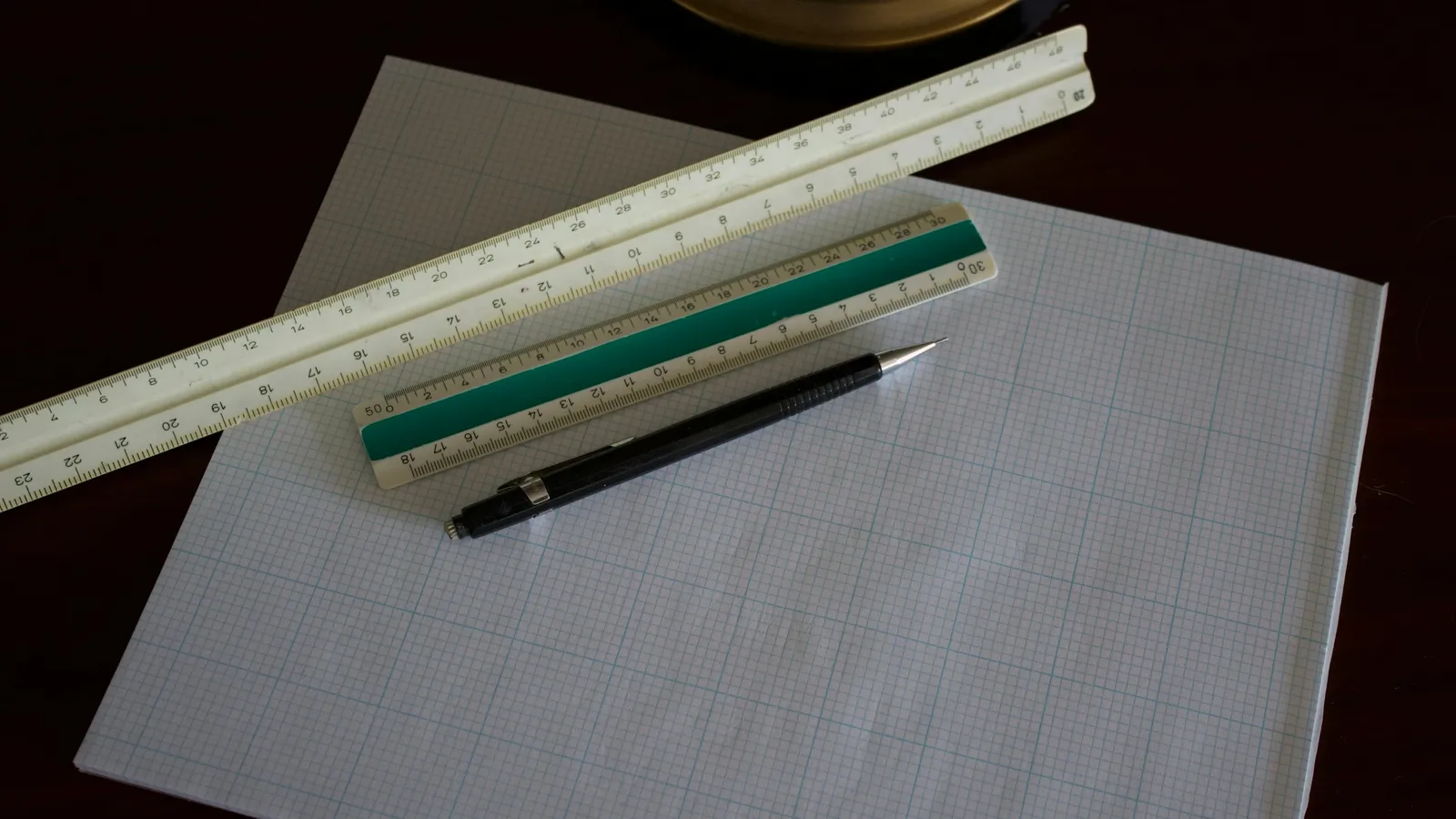 A ruler and pencils laid across a sheet of paper