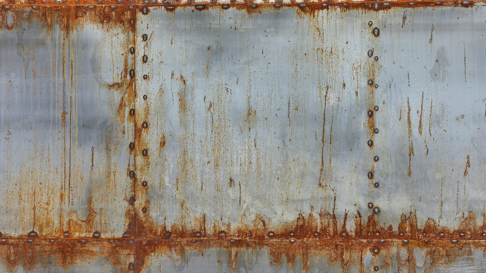 A rusting steel surface with streaks of corrosion