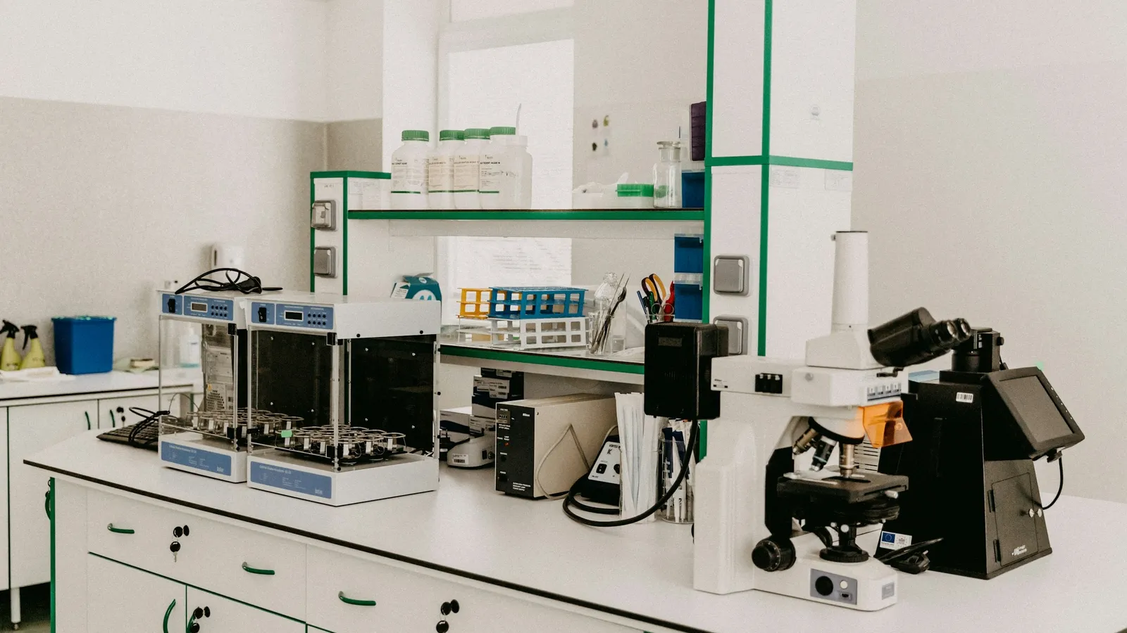 A science laboratory with white benches, microscopes and lab equipment